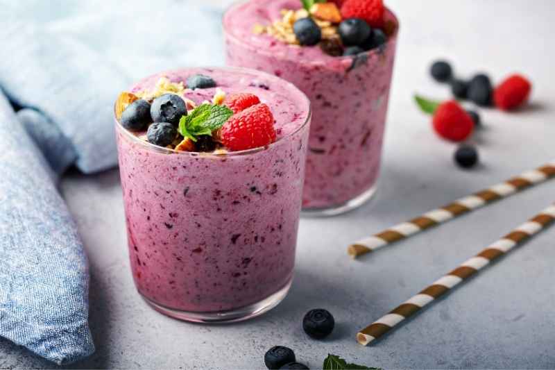 A vibrant pink-red berry smoothie in a glass jar, made for toddlers.