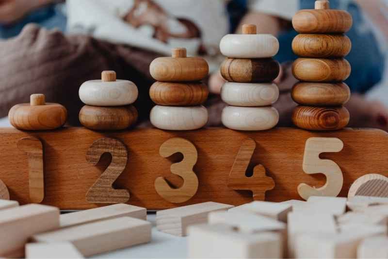 A toddler happily building colorful wooden blocks in a Montessori games learning activity. 
