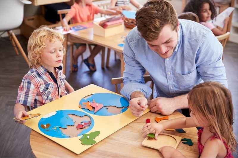 A boy and a girl playing puzzles with a man, engaging in a Montessori-inspired learning activity. 
