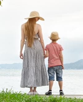 Mother and her toddler son sitting by the lakeside in the afternoon, enjoying a peaceful moment together.  Melting Rainbow