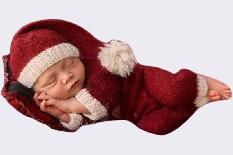 Newborn baby sleeping while wearing the Vedory Christmas Newborn Baby Photo Shoot Outfit, featuring a red crochet Santa hat and matching red pants; cozy and soft festive Christmas outfit for newborn photo shoots, holiday photography, and first Christmas memories.